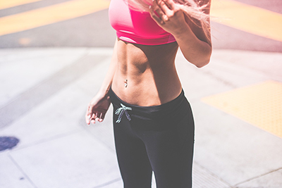 Woman in athletic wear showing flat tummy - Image by Pexels from Pixabay
