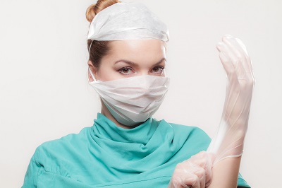 Nurse putting on medical gloves