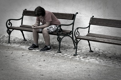 Child using a mobile phone on a bench