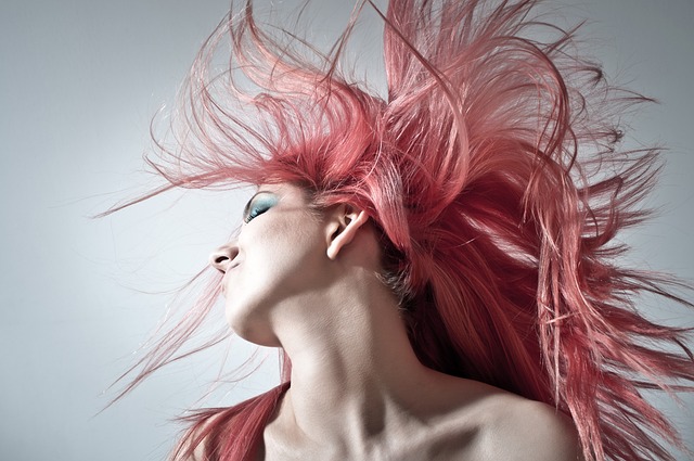 Photo of a woman's face, neck and shoulders with pink hair - by George from Pixabay