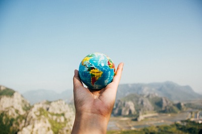 A hand holding a globe