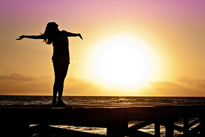 Silhouette of a happy carefree woman near sea