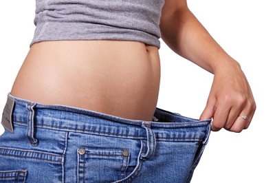 Woman wearing a pair of jeans that are too large for her waist